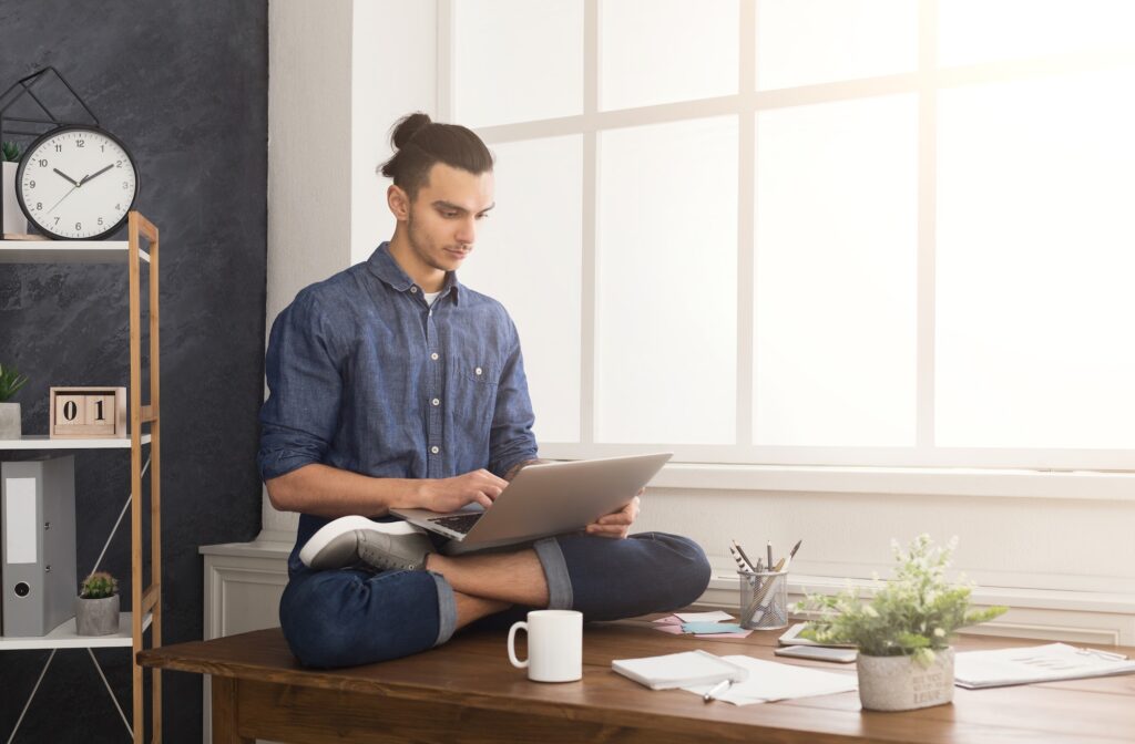 Flexible man practicing yoga at workplace