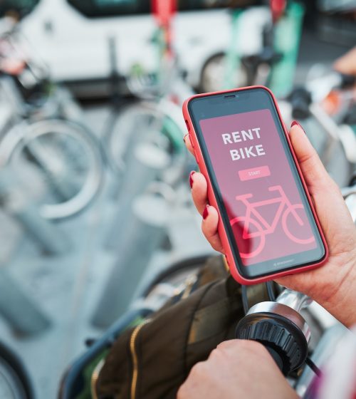 Renting bike using rental app on mobile phone. Using bike sharing city service. Mobile app